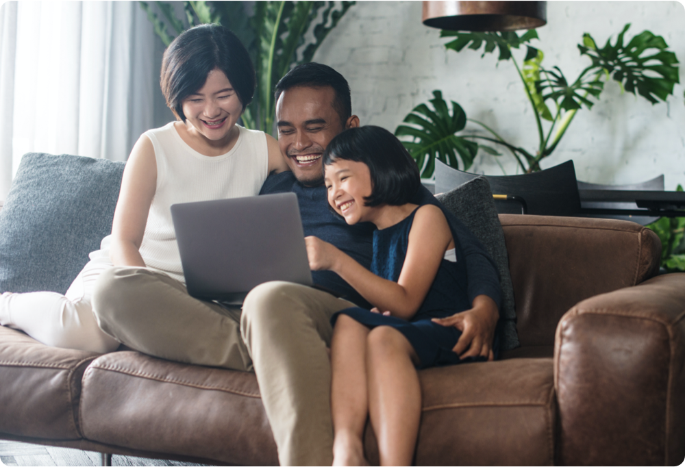 photo of family on couch looking at laptop
